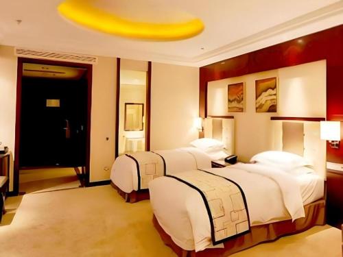 a hotel room with two beds with a banana on the ceiling at Northwest Petroleum Hotel in Ürümqi