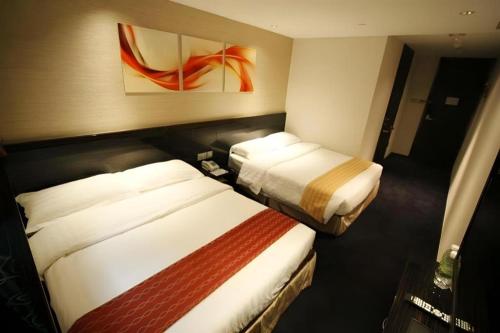 a hotel room with two beds in a room at Noble Park Hotel in Hong Kong