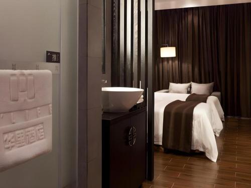 a bathroom with a bedroom with a bed and a sink at H Life Hotel Nanshan Branch in Shenzhen