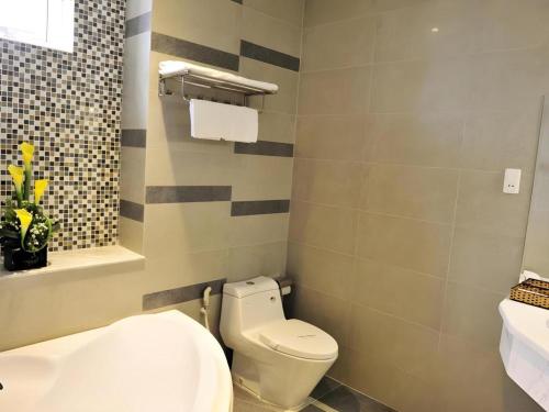 a bathroom with a white toilet and a sink at Phoenix Hotel Saigon in Ho Chi Minh City