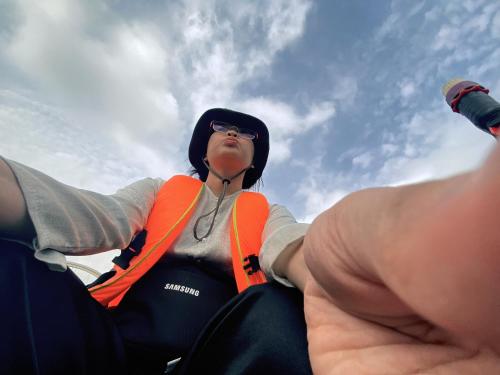 a woman in a wetsuit sitting in a hand at Dorm bed in center with balcony, rooftop and floating market tour by ADORA in Can Tho