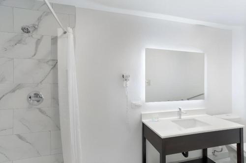 a white bathroom with a sink and a mirror at Quality Inn Redding near I-5 in Redding