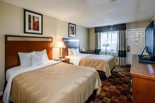 a hotel room with two beds and a flat screen tv at Quality Inn Redding near I-5 in Redding