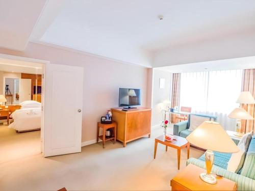 a living room with a couch and a television at Kai Wah Plaza International Hotel in Kunming