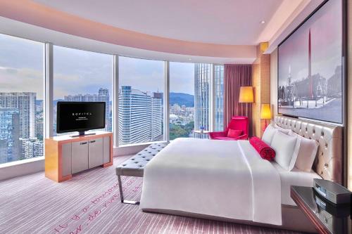 a hotel room with a large bed and a television at Sofitel Guangzhou Sunrich - Free Shuttle Bus to Canton Fair Complex & Overseas Buyer Registration Services during Canton Fair Period in Guangzhou