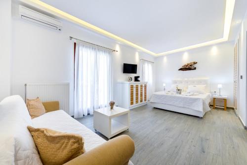 a white room with two beds and a couch at William's Houses in Akrotiri