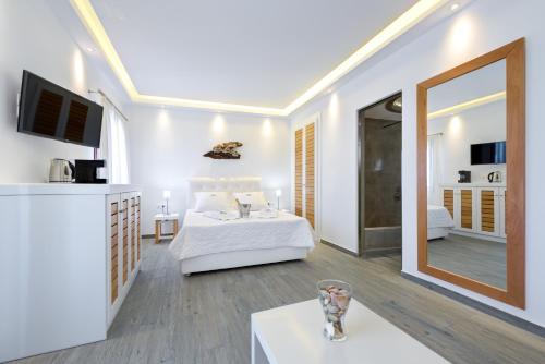 a hotel room with a bed and a mirror at William's Houses in Akrotiri