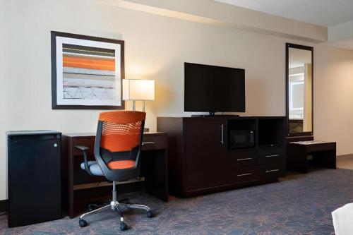a room with a desk with a chair and a television at Best Western Plus Executive Inn in Toronto