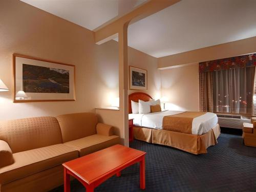 a hotel room with a bed and a couch at Best Western Plus Executive Inn in Toronto