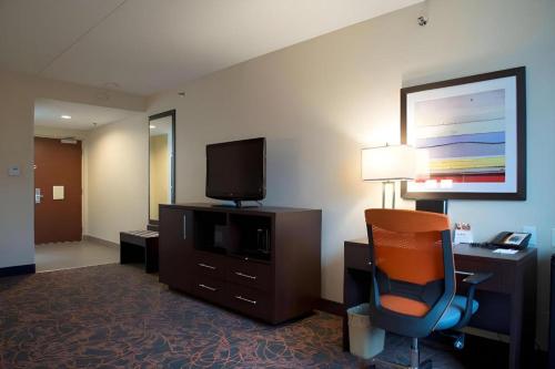 a hotel room with a desk and a chair and a television at Best Western Plus Executive Inn in Toronto