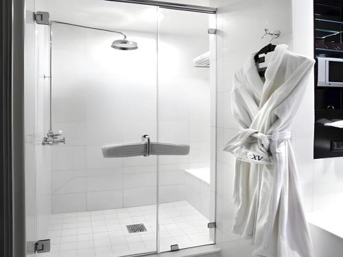 a shower with a white robe hanging on a wall at Fifteen Beacon Hotel in Boston