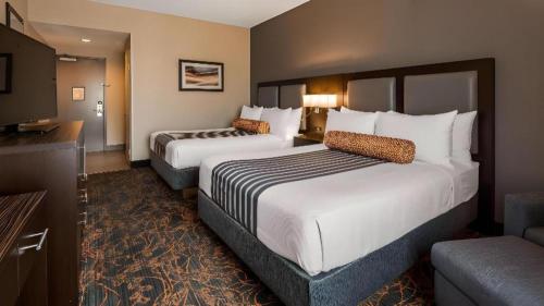 a hotel room with two beds and a television at Best Western Plus Executive Inn in Toronto