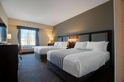 a hotel room with two beds and a window at Best Western Plus Executive Inn in Toronto