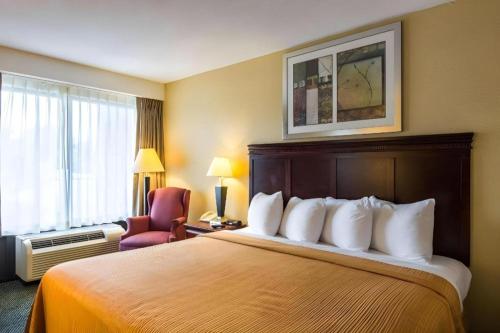 a hotel room with a bed and a chair at Quality Inn in Manassas