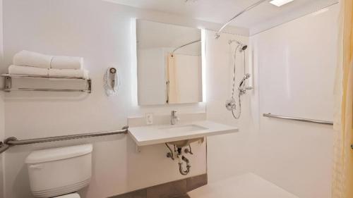 a white bathroom with a toilet and a sink at Best Western Galt Inn in Galt