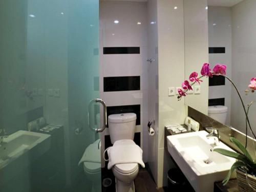 a bathroom with a toilet and a sink at Brits Hotel Karawang in Karawang