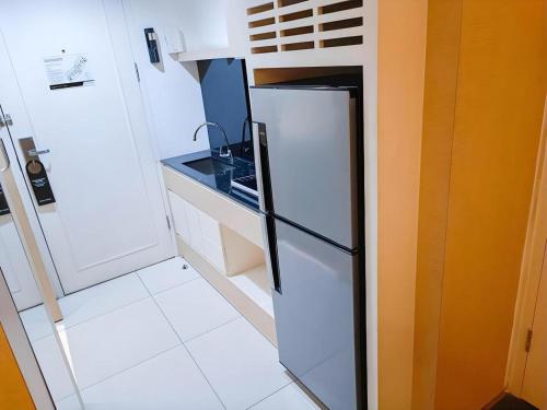 a small kitchen with a refrigerator and a stove at Brits Hotel Karawang in Karawang