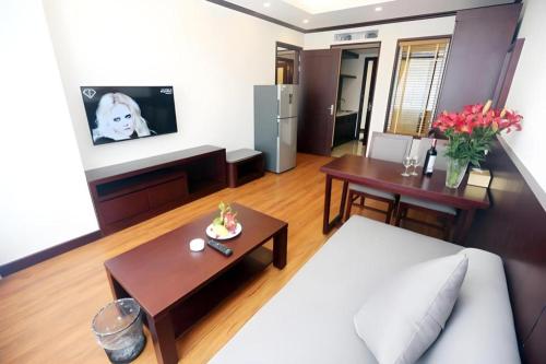 a living room with a couch and tables and a tv at Lenid Hotel Tho Nhuom in Hanoi