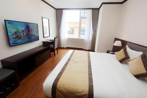 a hotel room with a large bed and a flat screen tv at Lenid Hotel Tho Nhuom in Hanoi
