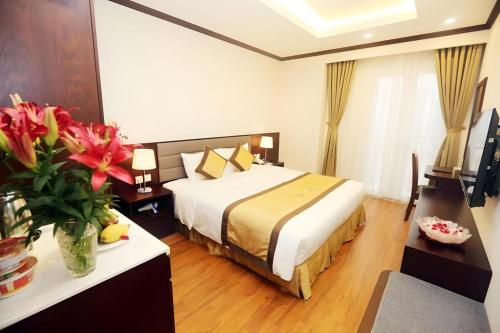 a hotel room with a bed and flowers in a room at Lenid Hotel Tho Nhuom in Hanoi