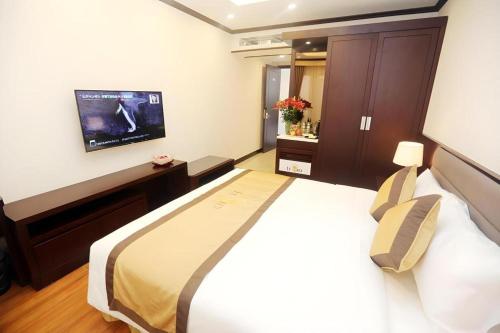 a hotel room with a bed and a tv at Lenid Hotel Tho Nhuom in Hanoi