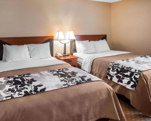a hotel room with two beds and a telephone at Rodeway Inn & Suites Salina South in Salina