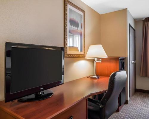 a desk with a computer monitor and a chair at Rodeway Inn & Suites Salina South in Salina