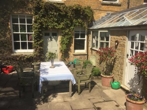 a patio with a table and chairs and a building at Ellesmere House in Castle Cary