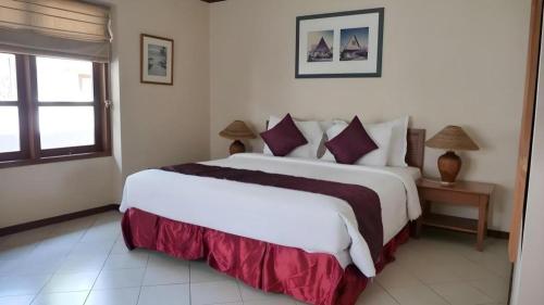 a bedroom with a large white bed and a window at Tanjung Lesung Beach Hotel in Carita