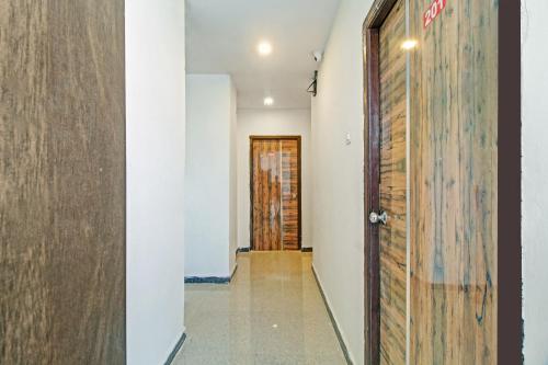 a corridor with a wooden door and a hallway with at Hotel O A Delight Residency in Surūrnagar