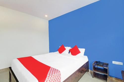 a bedroom with a bed with red pillows at Hotel O A Delight Residency in Surūrnagar