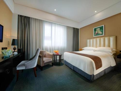 a hotel room with a bed and a desk and a chair at New Century Manju Hotel Shanghai New International Expo Center in Shanghai