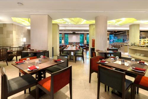 a dining room with tables and chairs in a restaurant at The Mirador in Mumbai