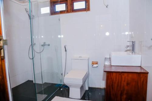 a bathroom with a shower and a toilet and a sink at Grand Leisure Care & Wellness Resort in Negombo