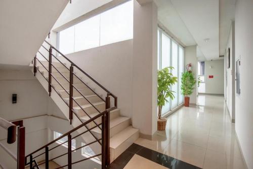 a hallway with stairs in a building with a window at Raffleshom Hotel in Bandung