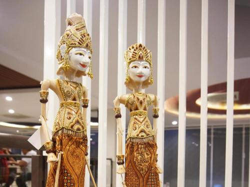 two gold statues of women standing next to each other at Raffleshom Hotel in Bandung