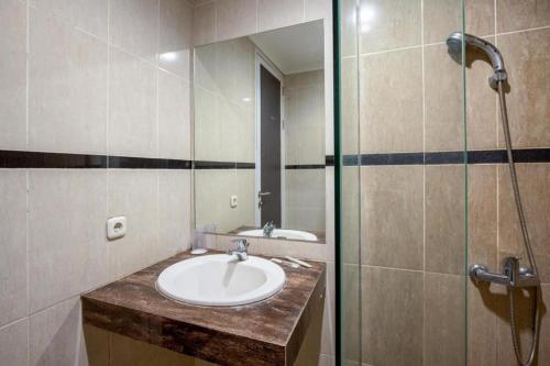 a bathroom with a sink and a shower at Raffleshom Hotel in Bandung