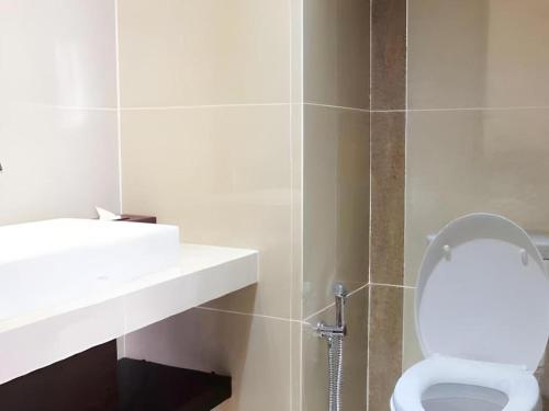 a bathroom with a white toilet and a sink at The Belagri Hotel and Convention in Sorong