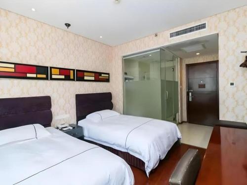 a bedroom with two beds and a sliding glass door at Yiwu Baiheng Hotel in Yiwu