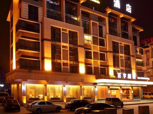 a building with cars parked in front of it at night at Yiwu Baiheng Hotel in Yiwu