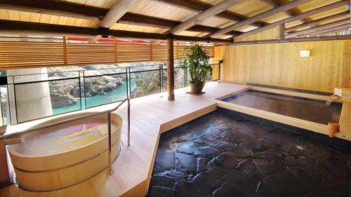 a large indoor swimming pool in a room with a large window at Hotel Obokekyo Mannaka in Miyoshi