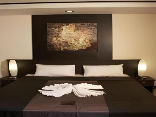 a bedroom with a large bed with a black headboard at Grand Pinnacle Hotel in Lat Krabang