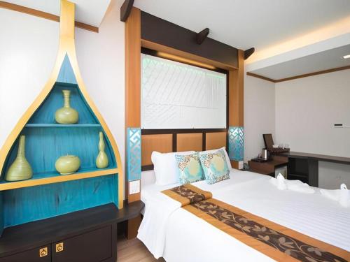 a bedroom with a bed with a blue headboard at Phi Phi Nice Beach Hotel Hip in Phi Phi Don