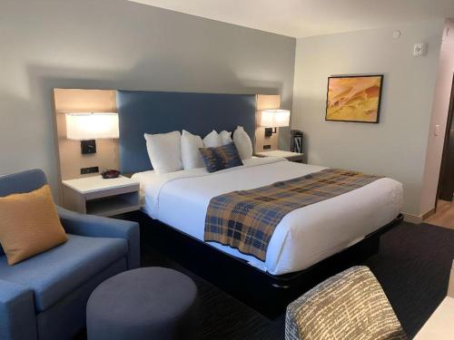 a hotel room with a large bed and a blue couch at Best Western Lake Lucille Inn in Wasilla