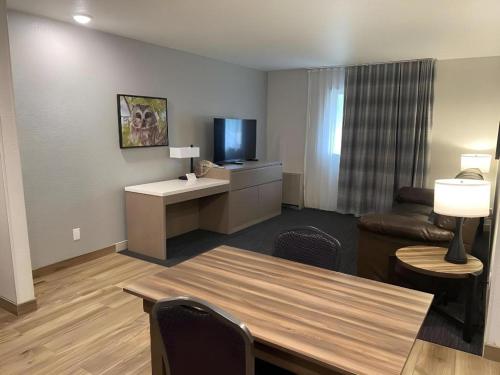 a living room with a table and a couch and a television at Best Western Lake Lucille Inn in Wasilla