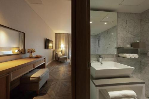 a bathroom with a sink and a mirror and a sink at Hotel Illua in Busan
