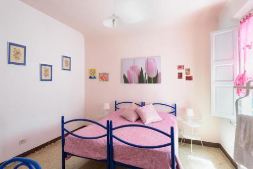 - une chambre avec un lit bleu et des draps roses dans l'établissement Casa di Osio, à Sienne