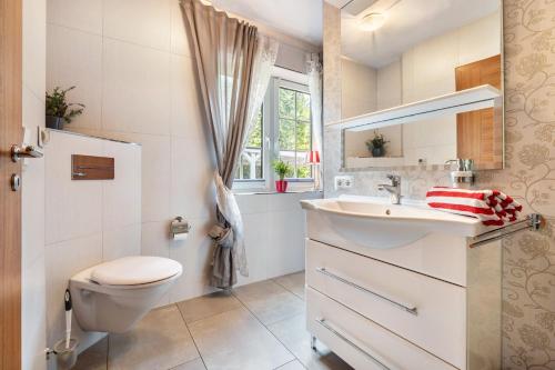a bathroom with a sink and a toilet and a window at Traumhaus Whirlpool Sauna Grill in Hamburg