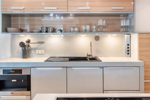 a kitchen with white cabinets and a sink at Traumhaus Whirlpool Sauna Grill in Hamburg