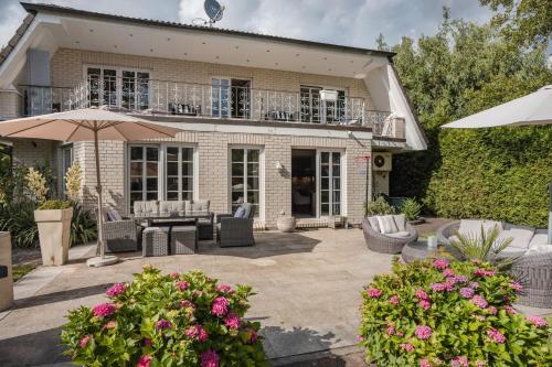 a house with a patio with chairs and an umbrella at Traumhaus Whirlpool Sauna Grill in Hamburg